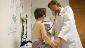 Una pediatra ausculta a un niño con su fonendoscopio.