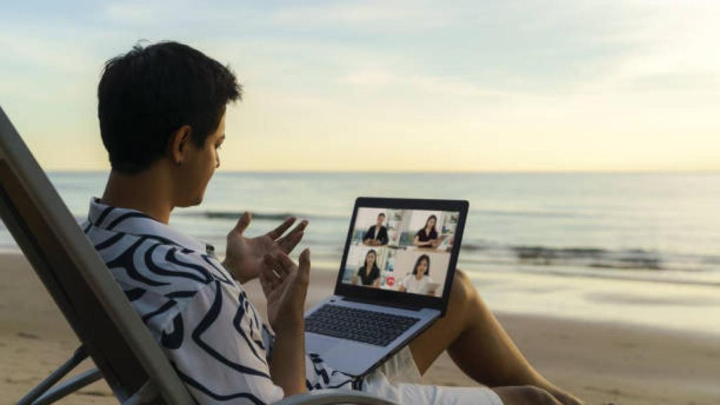 Una persona teletrabajando desde la playa