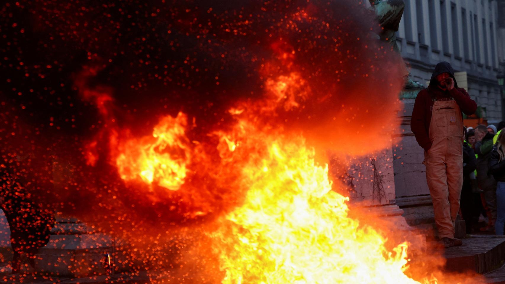 Una persona camina junto a una hoguera encendida en las protestas agrícolas en Bruselas el 1 de febrero de 2024.