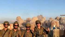 Cuatro soldados israelíes posan mientras bombardean Juzaa, donde se han destruido casi 200 casas.
