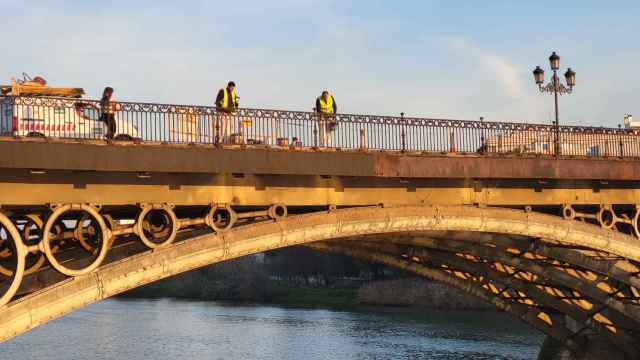 Operarios realizando obras de acondicionamiento en el Puente de Triana. EP