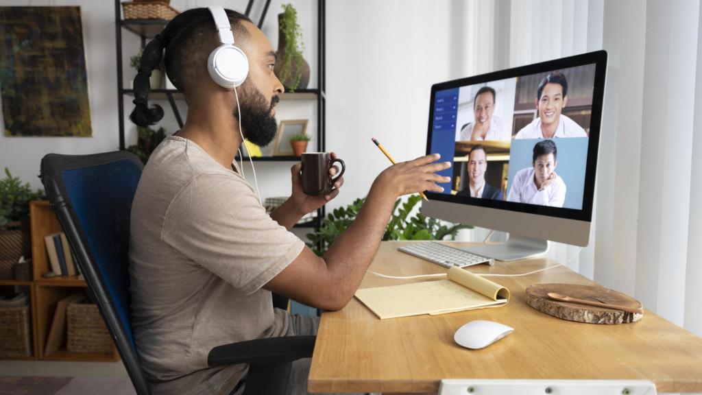 Un hombre habla por videollamada mientras teletrabaja.