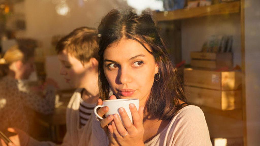 Una mujer bebiendo café.