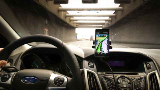 Un conductor usa un smartphone para ver los mapas mientras conduce