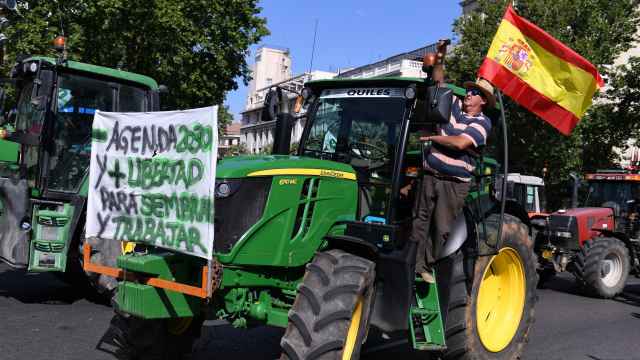 Un hombre subido a un tractor participa en una tractorada convocada por la Unión de Uniones de Agricultores y Ganaderos, en las inmediaciones de la Puerta de Alcalá, a 5 de julio de 2023.