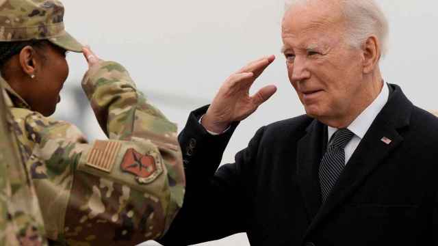 Joe Biden saluda a una militar en el aeropuerto donde han llegado los cuerpos de los militares asesinados.