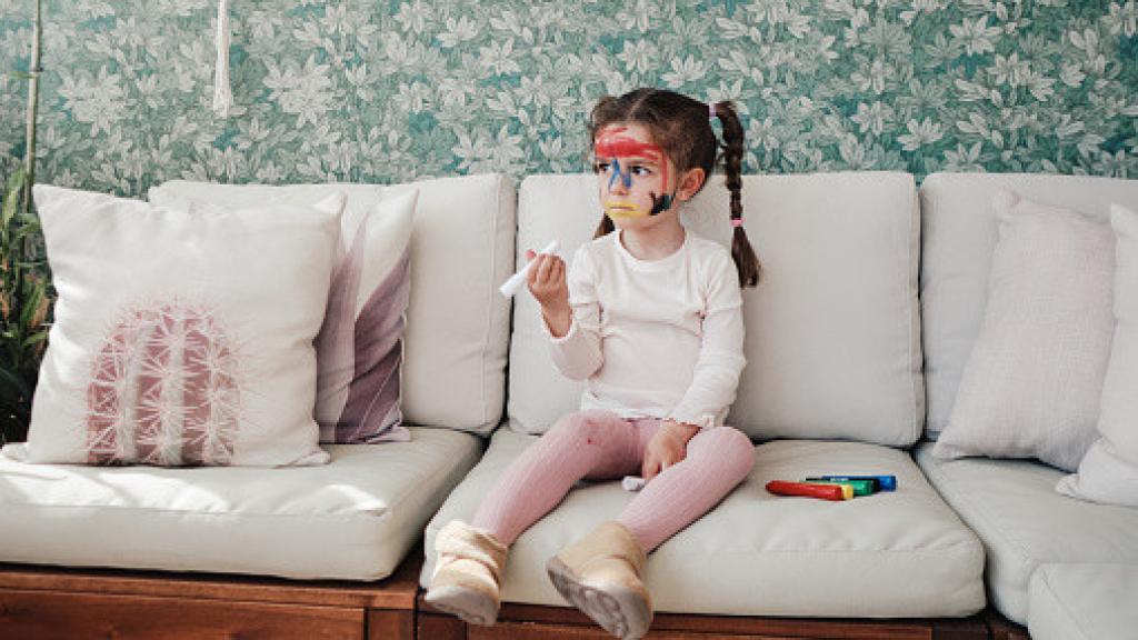 Detalle de un sofá con manchas de bolígrafo y café.