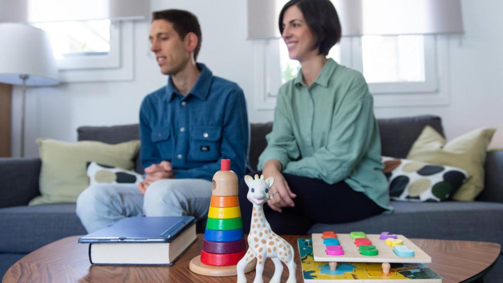 Julián y Alejandra en su casa, con la jirafa Sophie en primer plano.