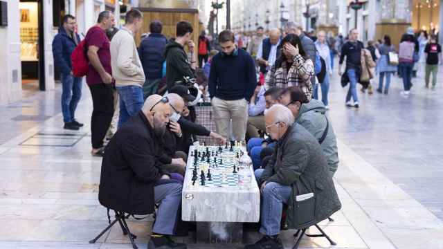 Un grupo de personas juega al ajedrez en la calle Larios de Málaga.