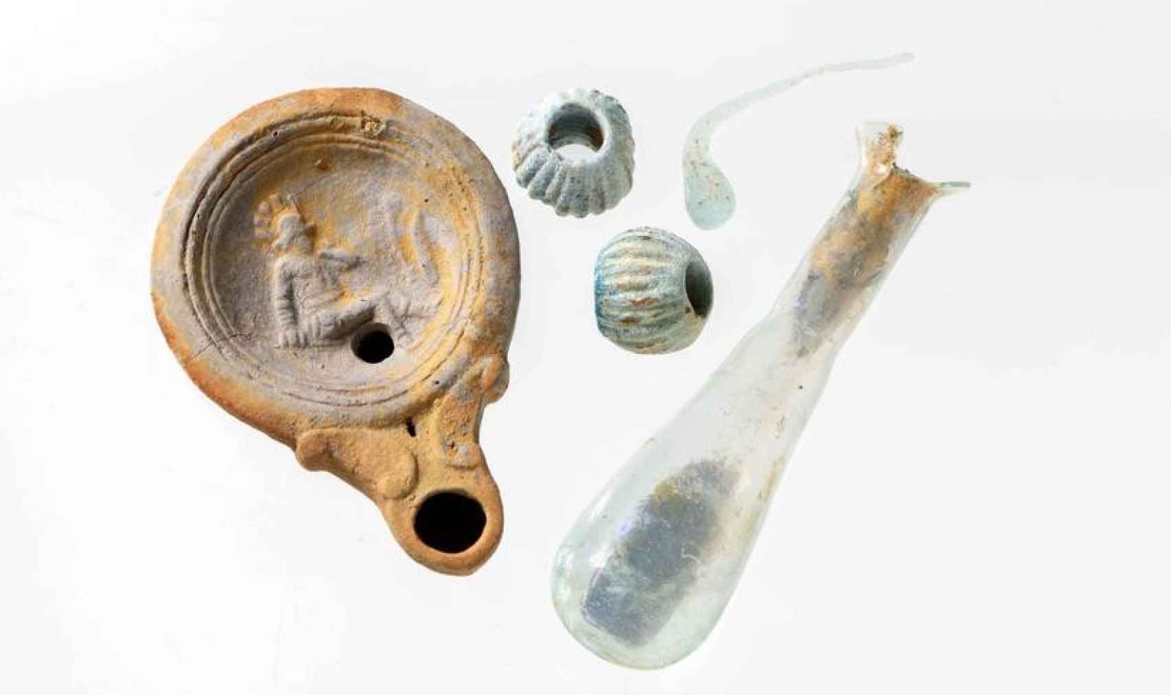 La lámpara con la imagen del gladiador derrotado y otros objetos hallados en el sitio.