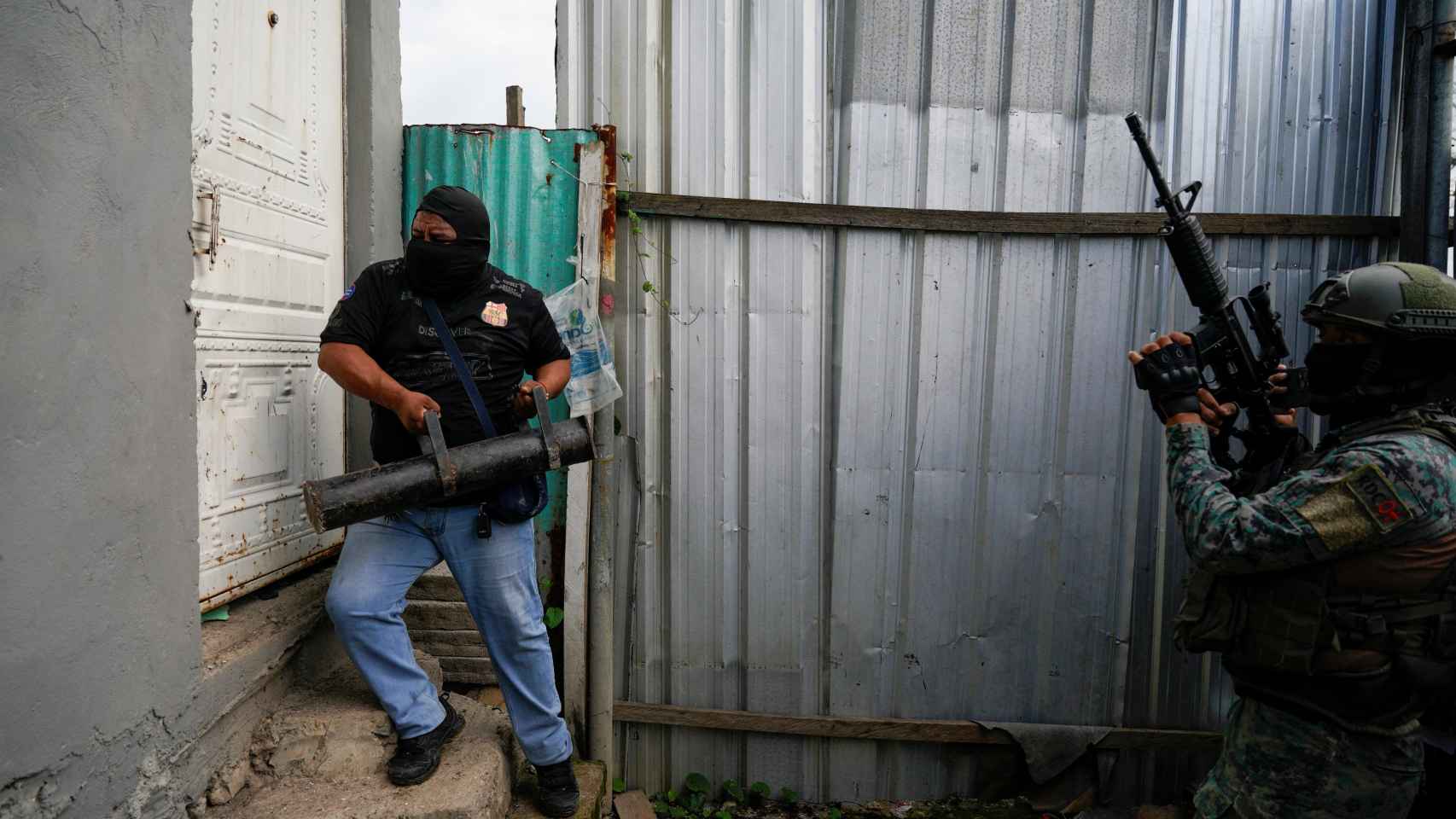 Un policía y un militar rompen una puerta durante una operación conjunta en un barrio de bajos ingresos de Durán (Ecuador).