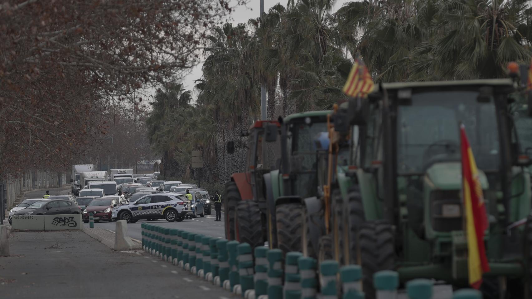 Agentes de la Policía Nacional y de la Local trabajan en la manifestación de agricultores con tractores que ha cortado la ronda norte de acceso a Valencia y la CV-30. Efe / Manuel Bruque