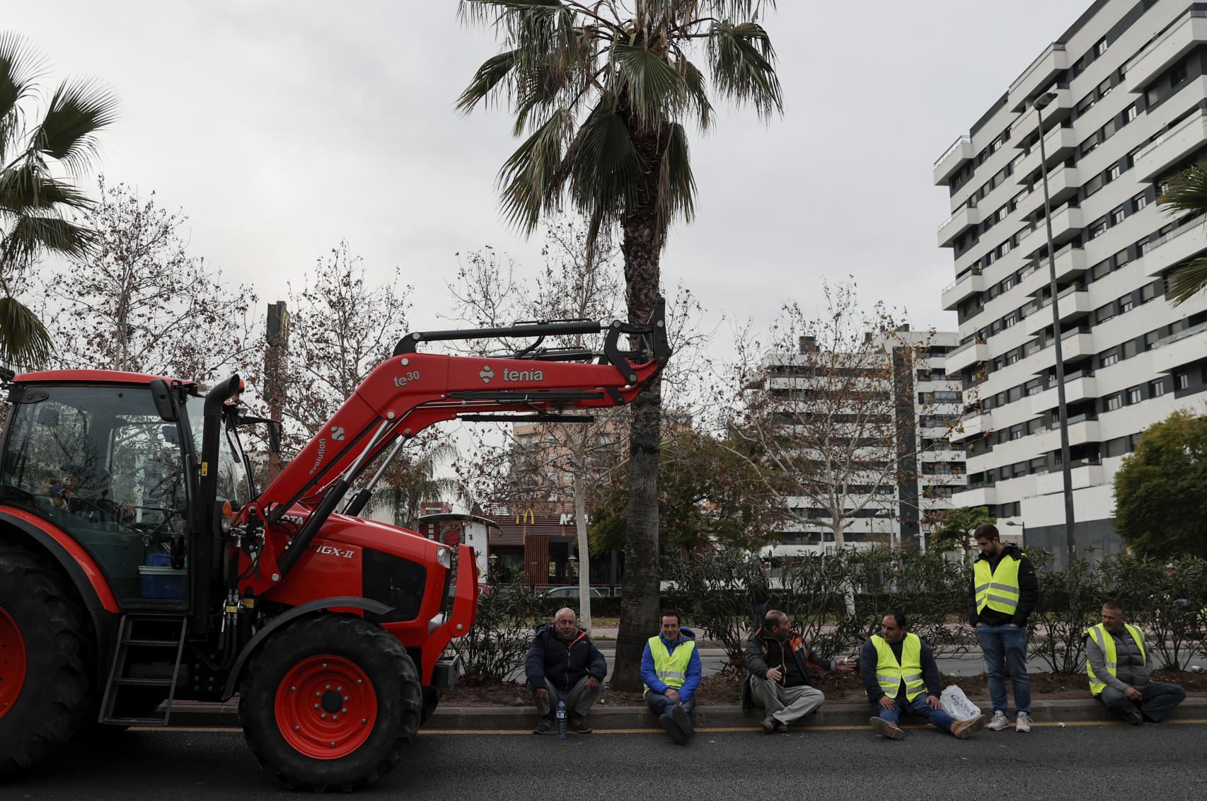 Varios agricultores durante la manifestación con tractores que ha cortado la ronda norte de acceso a Valencia. Efe / Manuel Bruque
