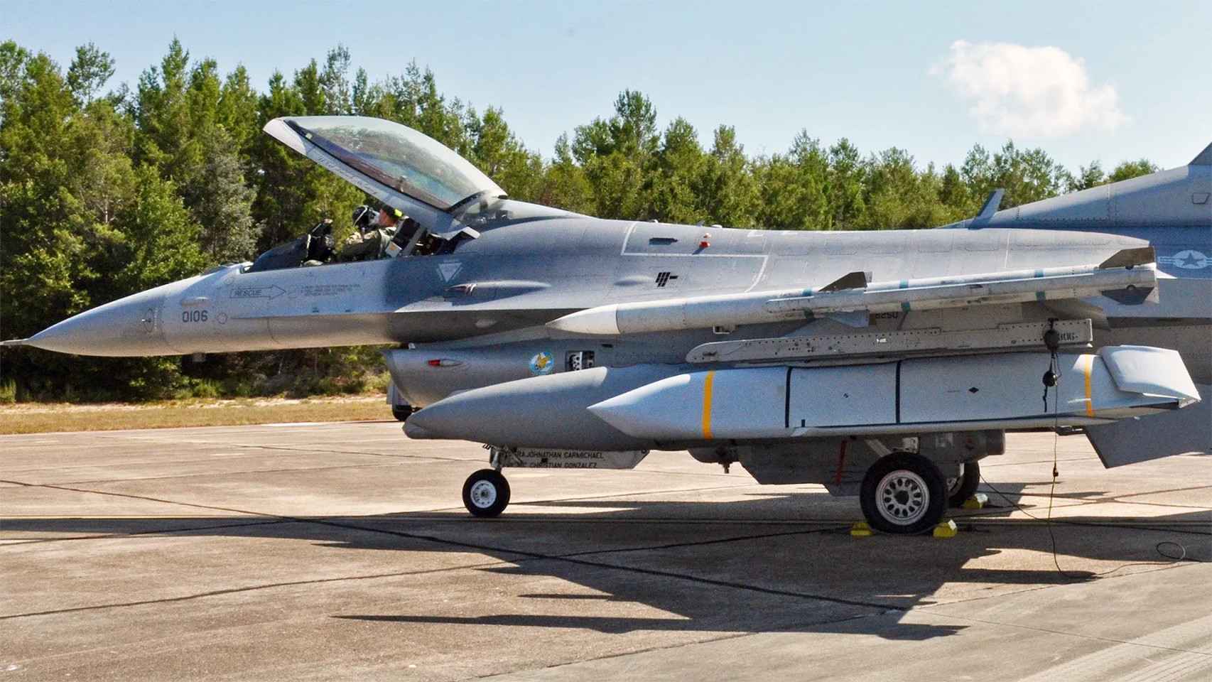 Avión F-16 con el AGM-158 (ribete amarillo) incorporado bajo el ala