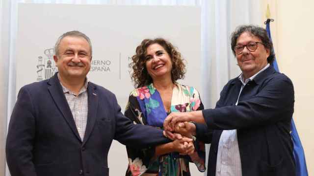 María Jesús Montero estrecha las manos de los responsables de Servicios Públicos de CCOO (i) y UGT (d) en 2022
