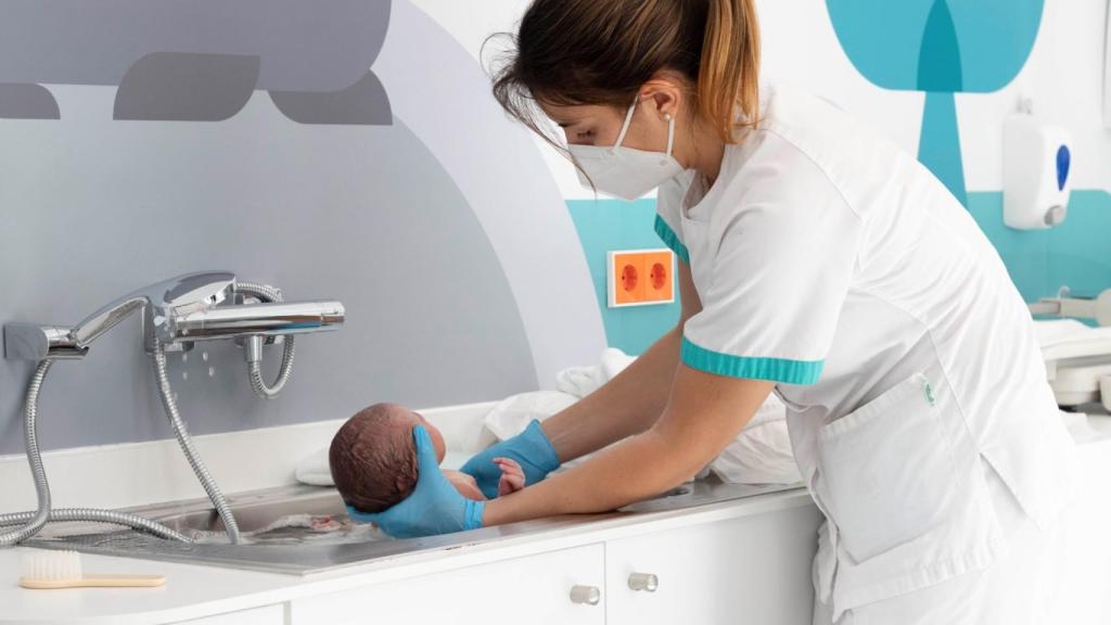 Una enfermera con un recién nacido en el Hospital Quironsalud Marbella.