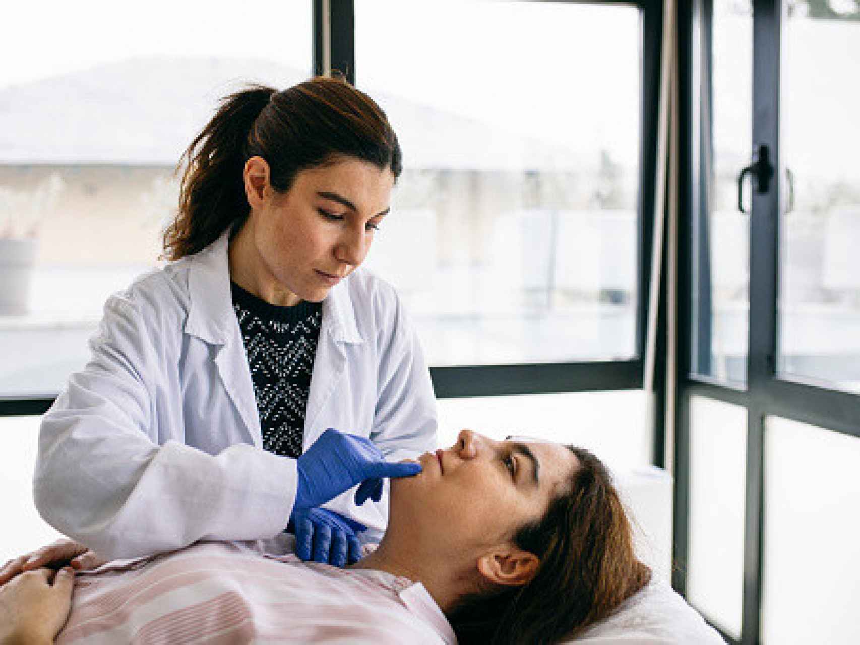 Un médico revisando a una mujer para su operación de cirugía.