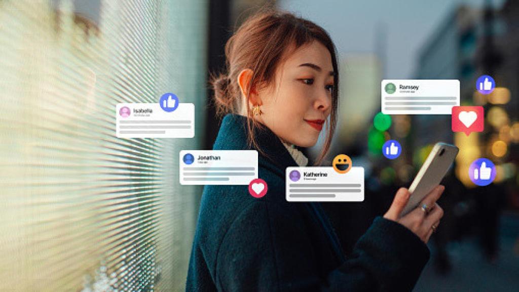 Una mujer recibiendo 'likes' y comentarios en su móvil.