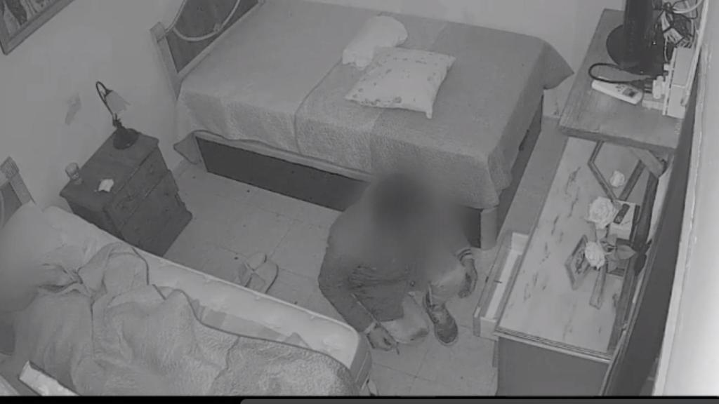 El ladrón, junto a su víctima, que duerme en la cama