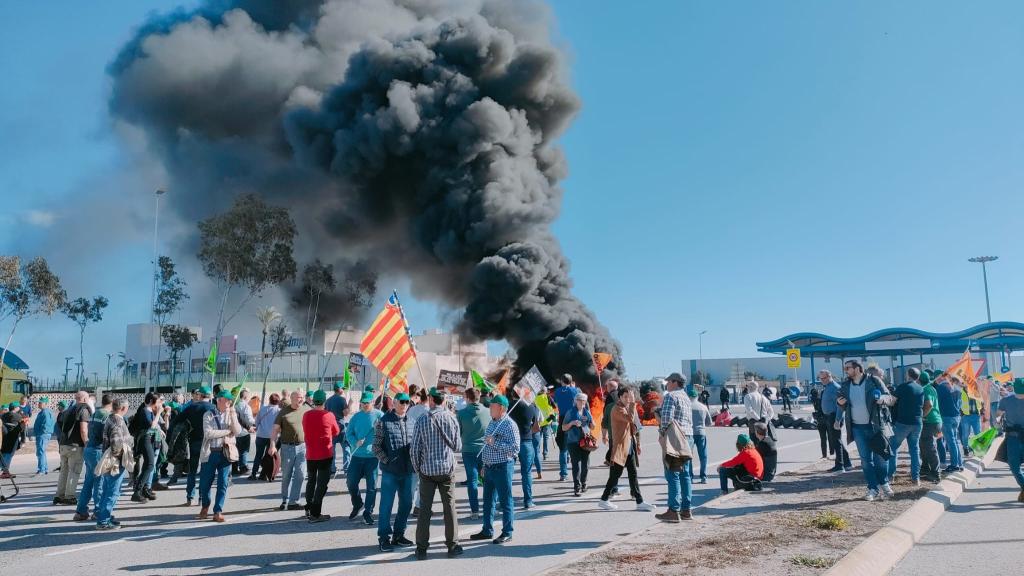 Unos agricultores cortan el acceso al Puerto de Castellón con una barricada de neumáticos.