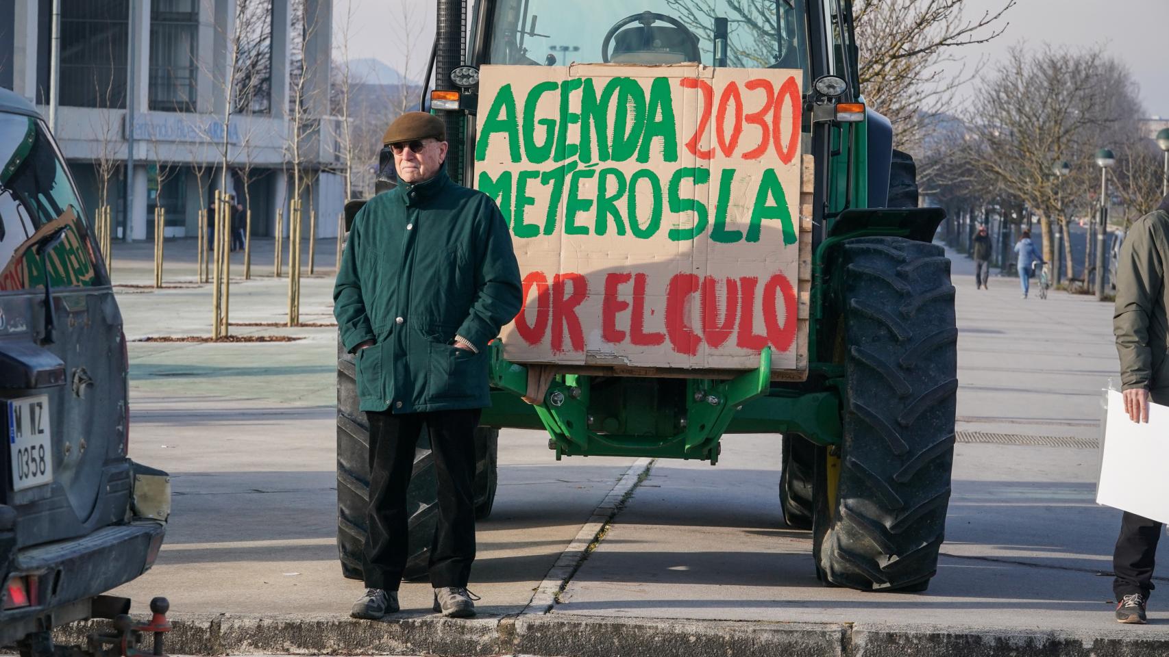 Un agricultor y un tractor con un cartel durante una concentración en la segunda jornada de protestas en Vitoria.