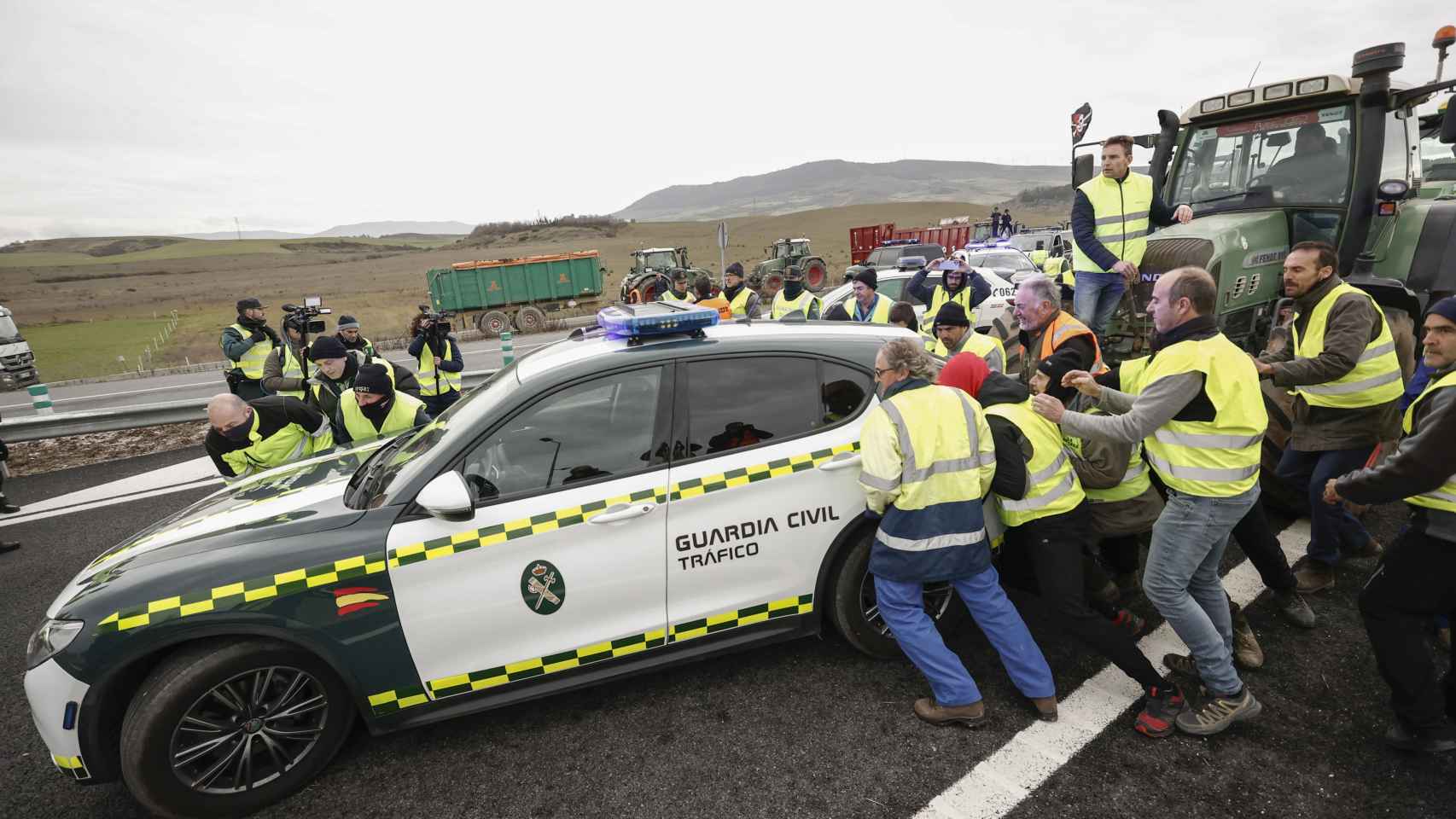 Agricultores mueven coches de la Guardia Civil para acceder a Pamplona.