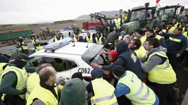 Agricultores mueven coches de la Guardia Civil para acceder a Pamplona este jueves.