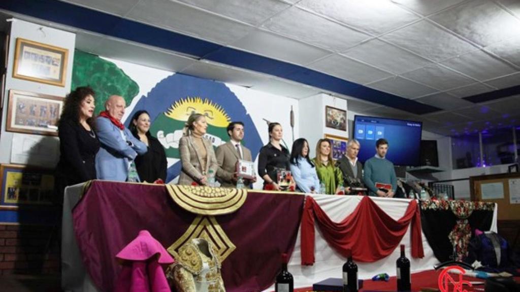 Componentes de la peña y los invitados en una pose tras los trofeos