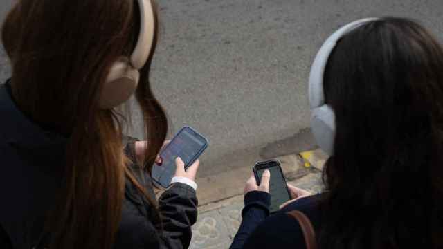 Dos jóvenes usan el teléfono móvil, a 1 de febrero de 2024, en Barcelona (España) (David Zorrakino/Europa Press)