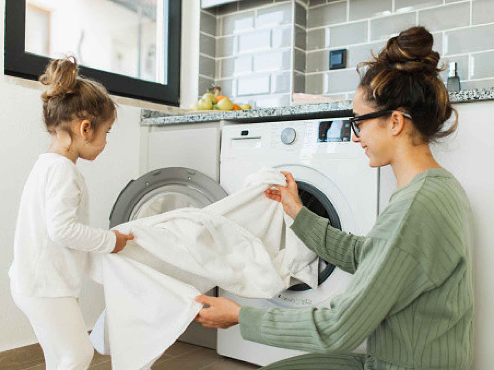 Una mujer y su hija limpiando la ropa.