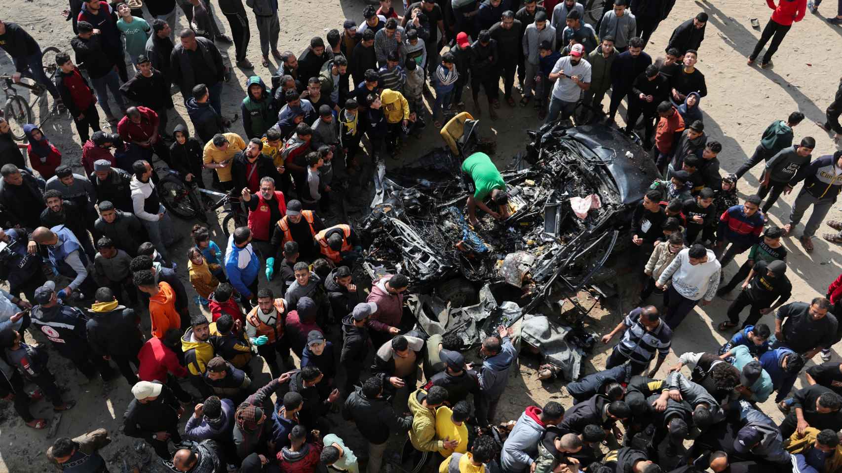Ciudadanos palestinos inspeccionan un automóvil tras ser alcanzado por un ataque israelí, en Rafah.