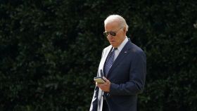 Joe Biden mira su teléfono desde el ala oeste de la Casa Blanca