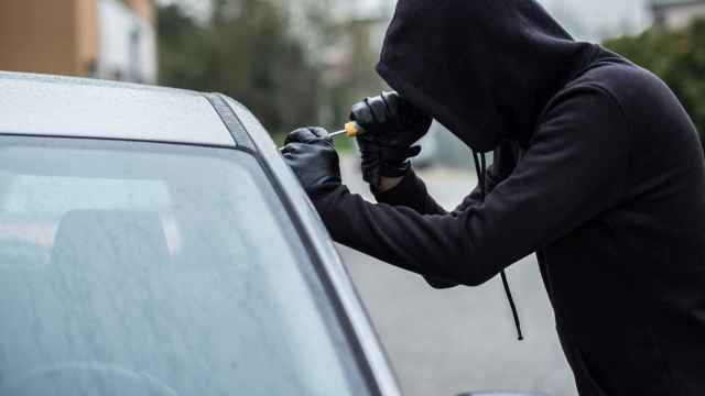 Una persona robando un coche.