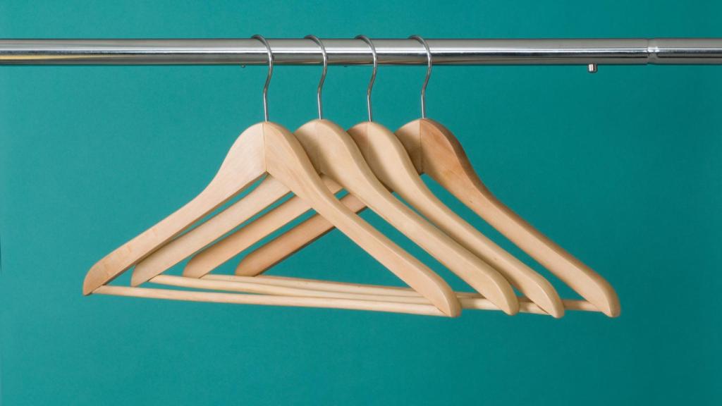 Imagen de unas perchas sobre un fondo verde.