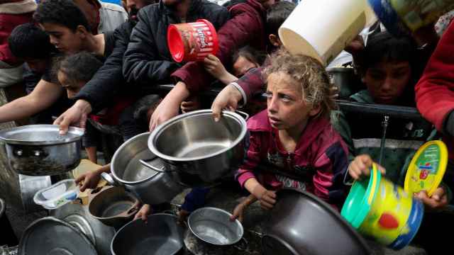 Niños palestinos pidiendo comida en una cocina benéfica en Rafah