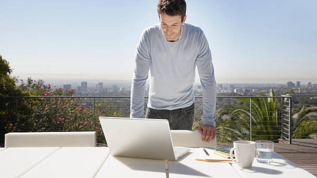 Una persona teletrabajando desde la terraza de su casa