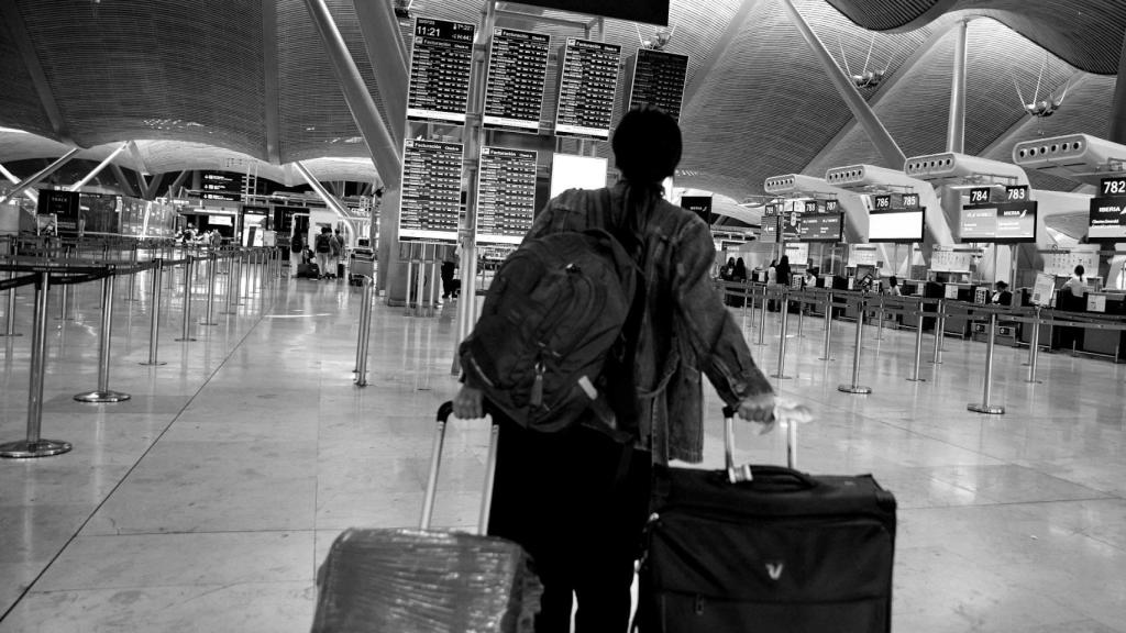 Una pasajera consulta un panel des salidas de vuelos en la zona de facturación de la Terminal 4 del Aeropuerto Adolfo Suárez Madrid-Barajas.
