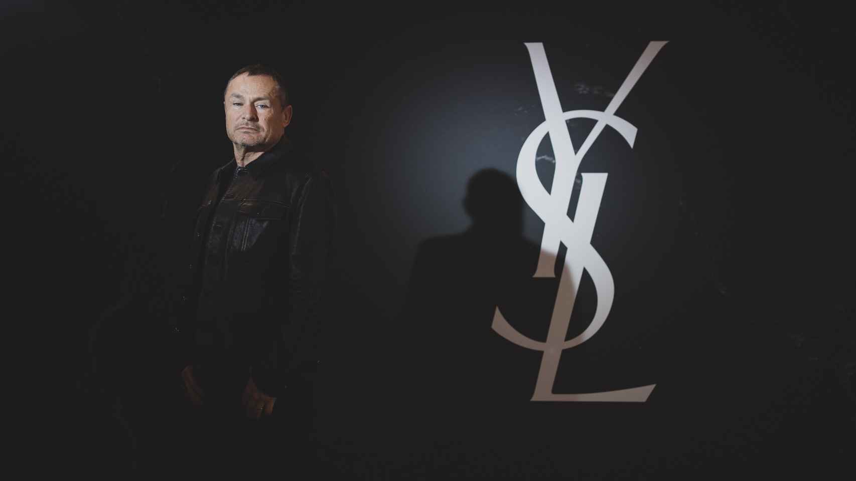 El maquillador YSL, Tom Pecheux, frente al símbolo de la marca.