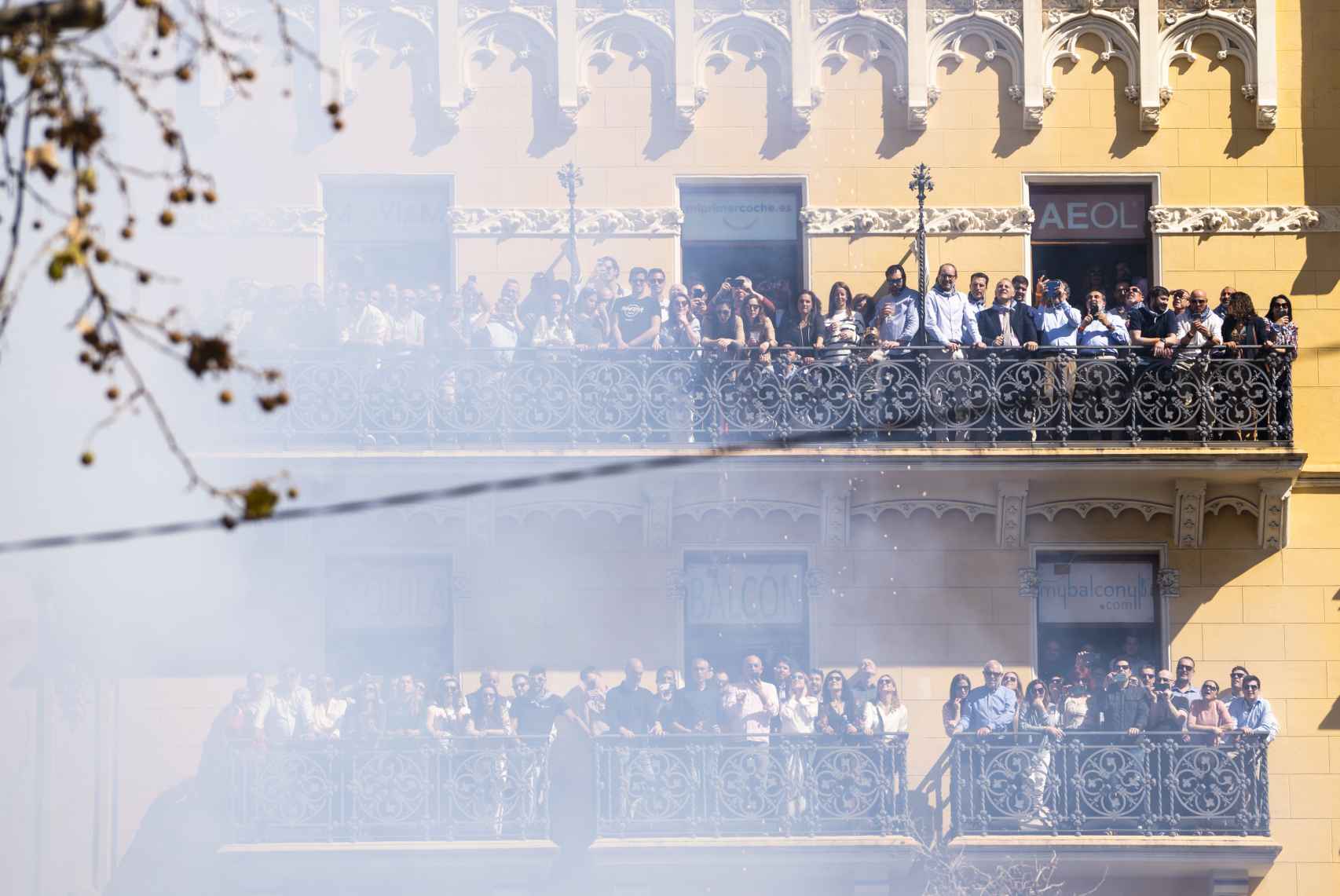 Decenas de personas ven la 'mascletà' desde sus balcones en la Plaza del Ayuntamiento de Valencia, a 15 de marzo de 2023.