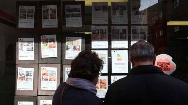 Una pareja mira los anuncios de una inmobiliaria en Valladolid.