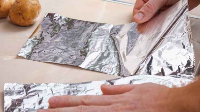 Persona cortando papel de aluminio.