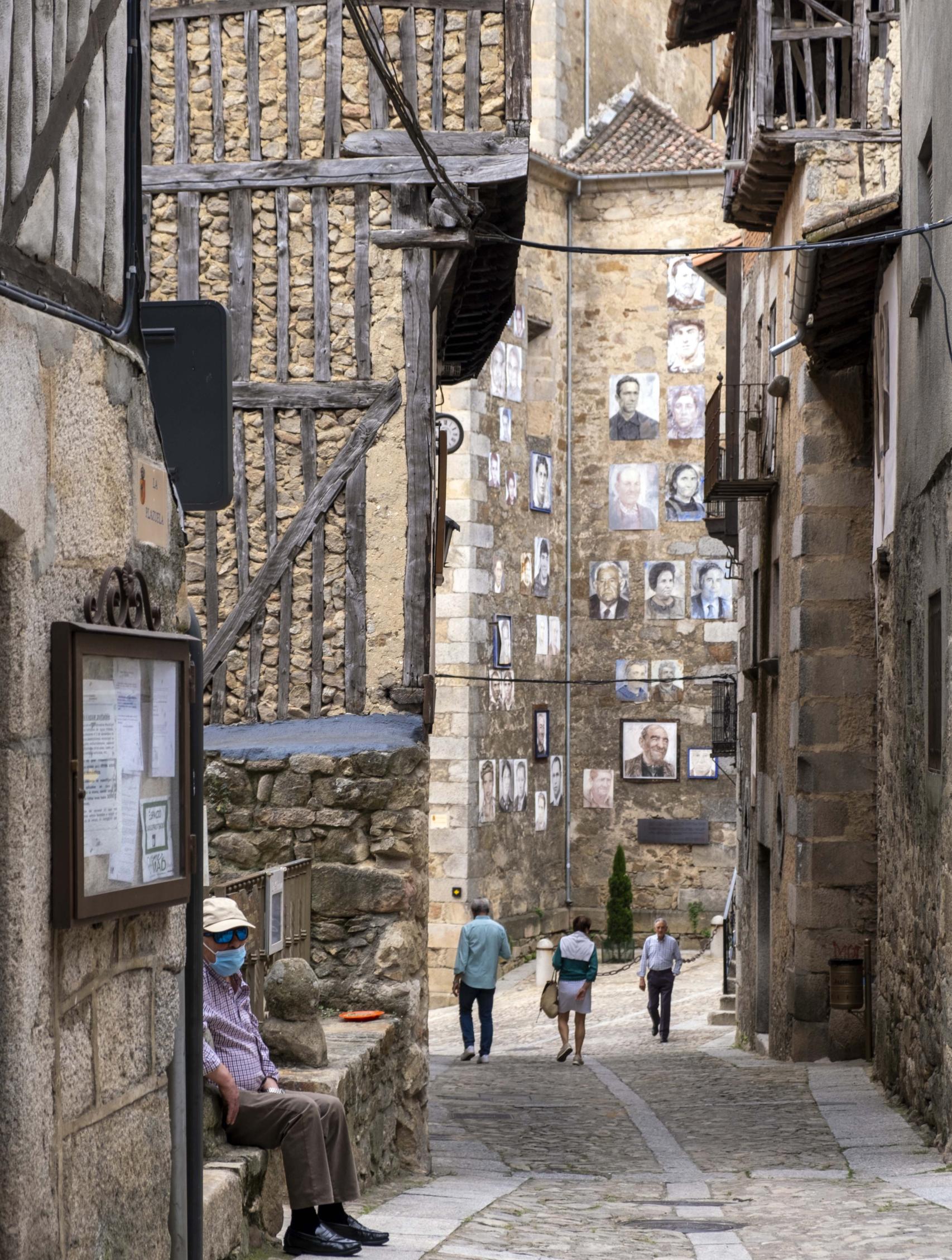 Una de las calles de Mogarraz, con algunos de los retratos al fondo