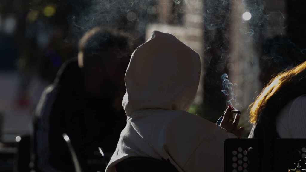 Una persona fumando en una terraza, a 27 de diciembre de 2023, en Madrid (España). EP