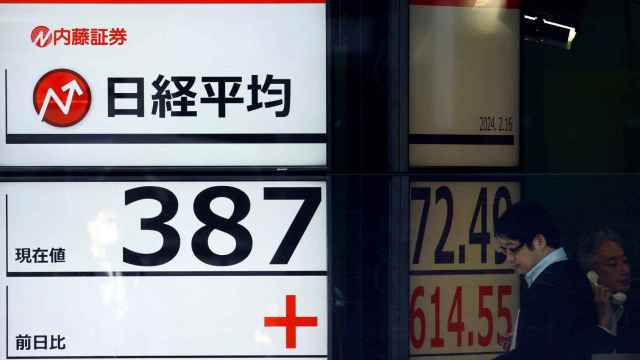 Un hombre cerca de una pantalla que muestra la cotización Nikkei en una agencia de valores de Tokio, Japón.