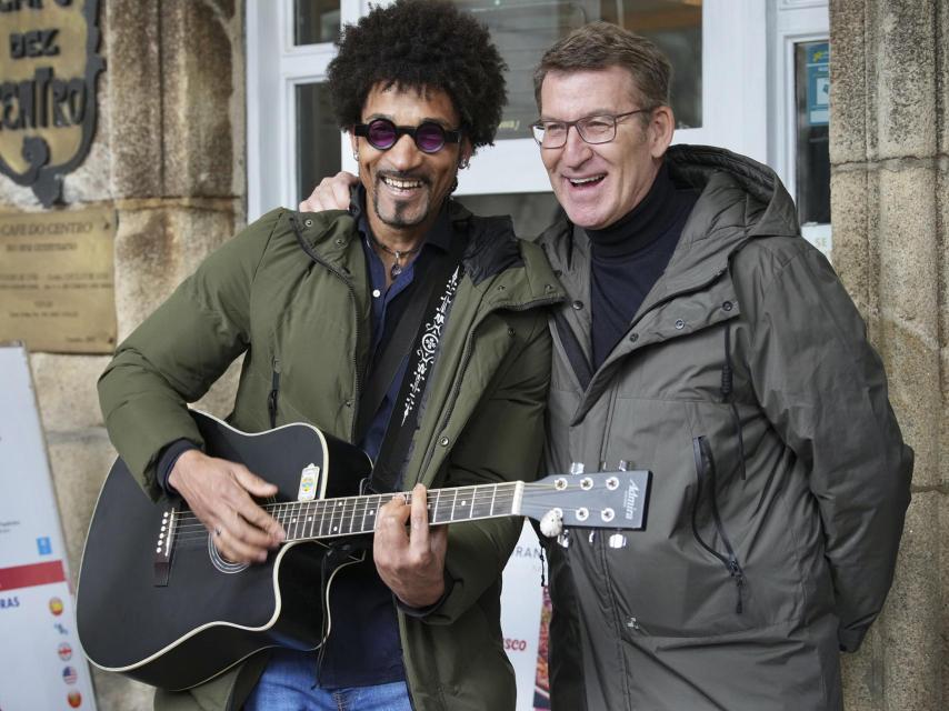 El líder del Partido Popular, Alberto Núñez Feijóo, bromea con un músico callejero.