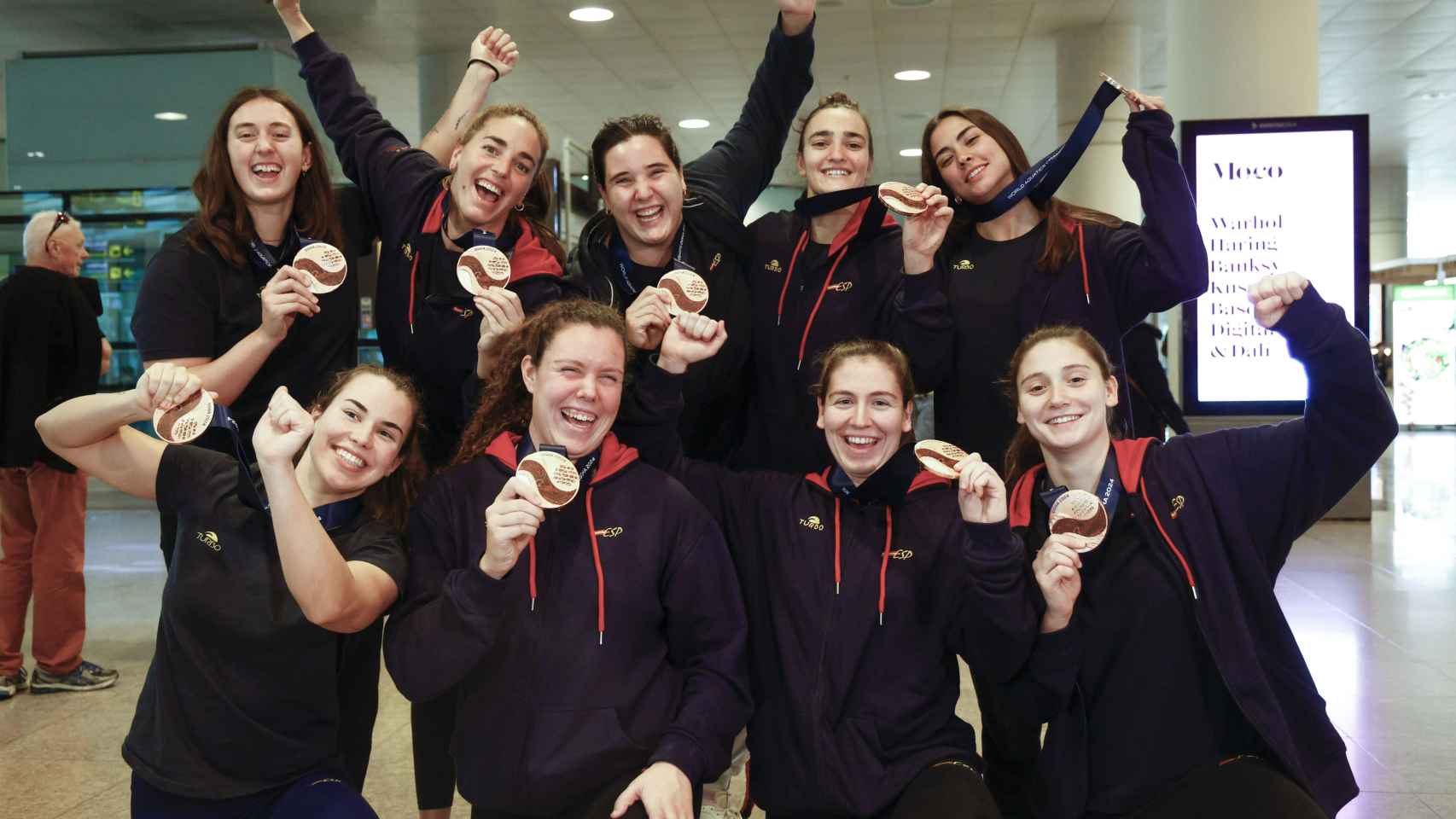 La selección española femenina de waterpolo, medalla de bronce en el mundial de Doha, posan para los medios de comunicación a su llegada al aeropuerto de Barcelona.