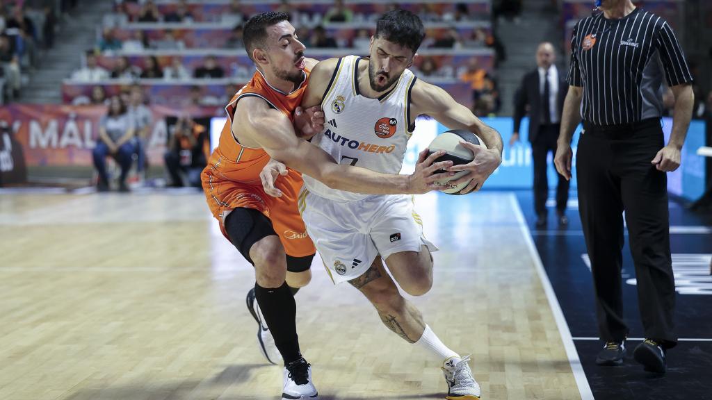 El base argentino del Real Madrid Facundo Campazzo (d) lucha con Josep Puerto, del Valencia Basket, durante el partido de semifinales de la Copa del Rey.