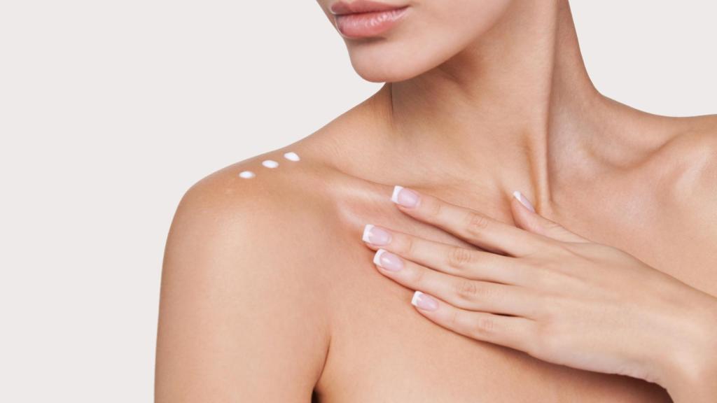 Una mujer aplicándose crema en el escote.
