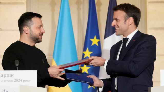 Macron y Zelenski intercambian documentos después de firmar el acuerdo de defensa