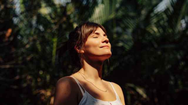 Una mujer con rostro de felicidad tomando el sol